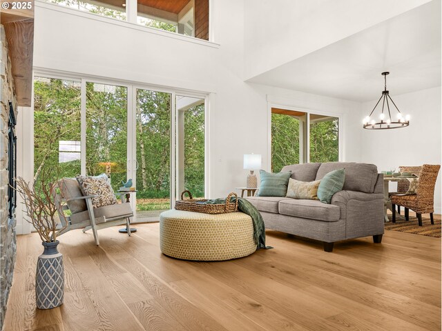 90202 Hobie Rd, Warrenton, OR 97146 - living room with a chandelier, light wood-style floors, and a towering ceiling