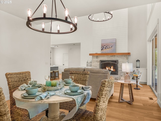 90202 Hobie Rd, Warrenton, OR 97146 - dining room featuring a chandelier, light wood finished floors, and a glass covered fireplace