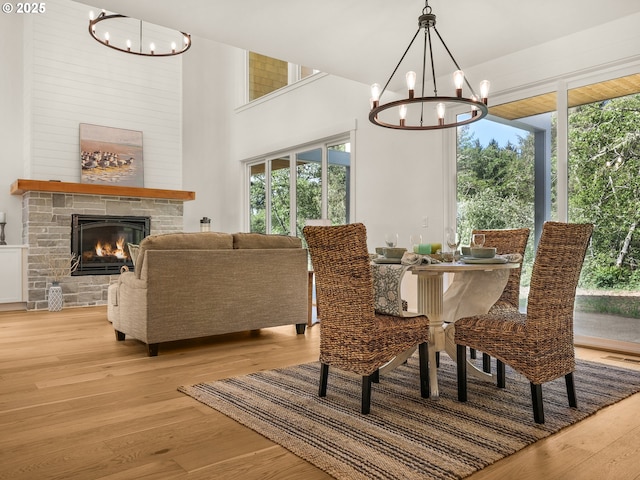90202 Hobie Rd, Warrenton, OR 97146 - dining space with a chandelier, light wood finished floors, and a stone fireplace