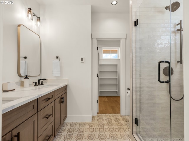 90202 Hobie Rd, Warrenton, OR 97146 - full bathroom with a stall shower, baseboards, double vanity, tile patterned flooring, and a spacious closet