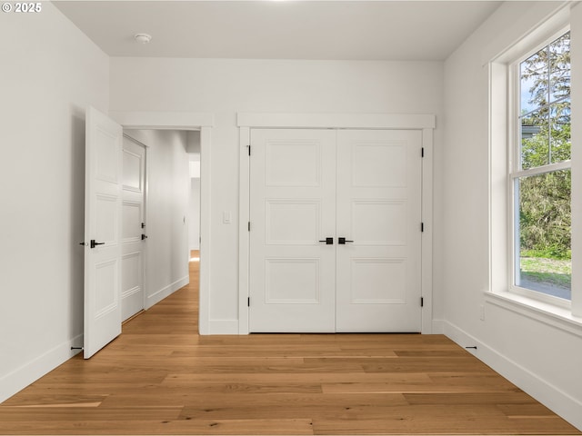 90202 Hobie Rd, Warrenton, OR 97146 - unfurnished bedroom featuring baseboards, light wood-style flooring, and a closet