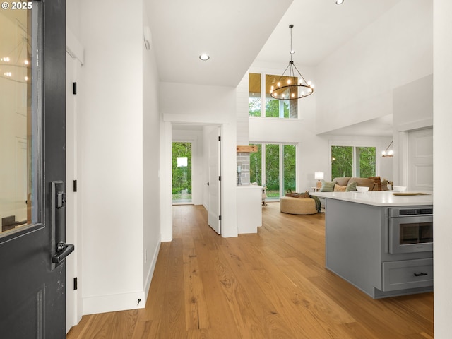 90202 Hobie Rd, Warrenton, OR 97146 - entrance foyer featuring a chandelier, a high ceiling, light wood-type flooring, baseboards, and recessed lighting