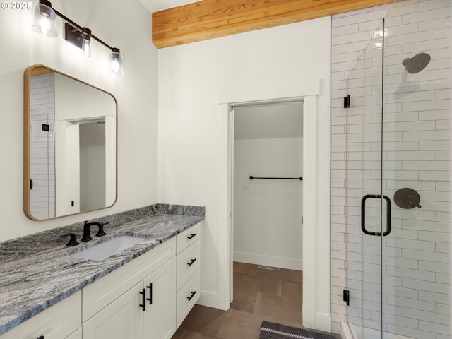 bathroom featuring a shower with door, vanity, and tile patterned floors