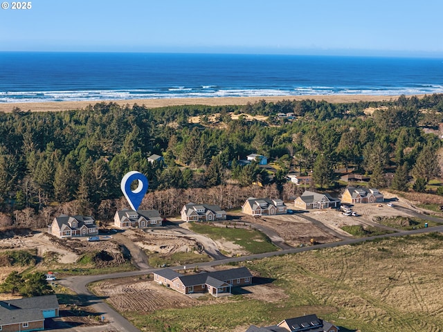 drone / aerial view featuring a water view and a beach view