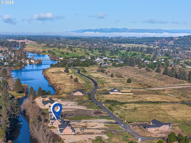 drone / aerial view featuring a water and mountain view