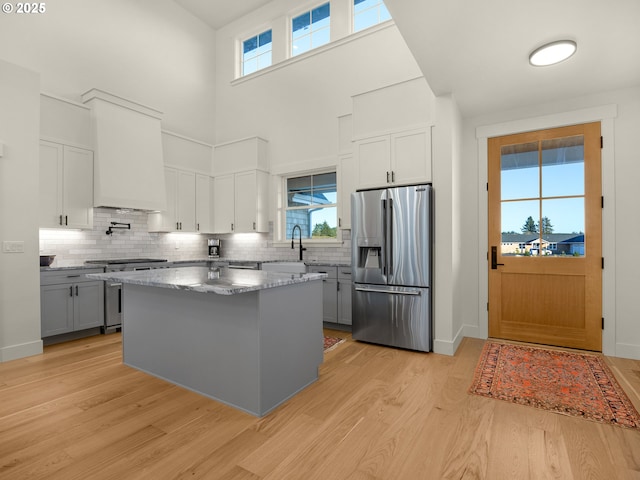 kitchen featuring sink, gray cabinets, a kitchen island, stainless steel appliances, and light hardwood / wood-style floors