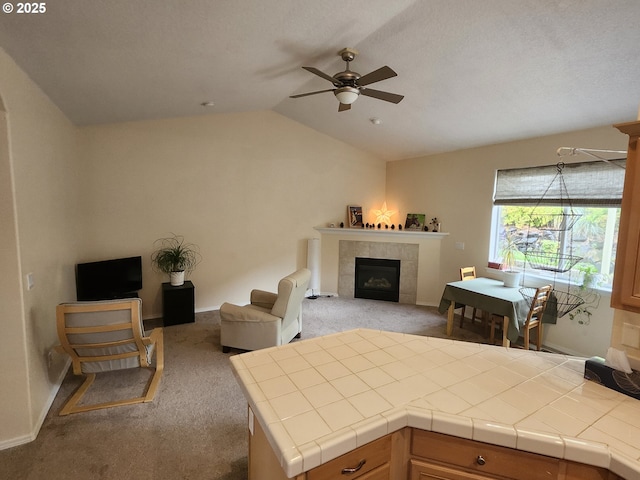 2405 Strasburg Dr, Forest Grove, OR 97116 - living area with light carpet, ceiling fan, vaulted ceiling, a tile fireplace, and baseboards