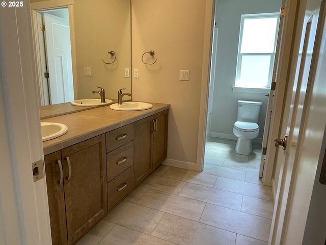 7827 SW Thornbridge Ter Unit 9, Beaverton, OR 97007 - bathroom featuring double vanity, toilet, tile patterned floors, and baseboards