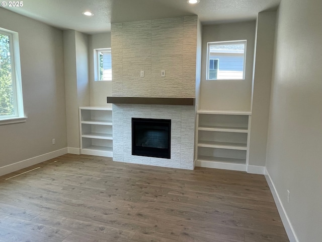 7827 SW Thornbridge Ter Unit 9, Beaverton, OR 97007 - unfurnished living room with baseboards, wood finished floors, a fireplace, and recessed lighting