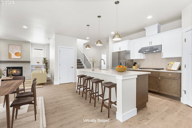 7827 SW Thornbridge Ter Unit 9, Beaverton, OR 97007 - kitchen featuring appliances with stainless steel finishes, under cabinet range hood, a sink, recessed lighting, and an island with sink