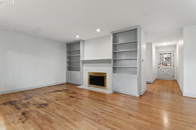 13980 Shireva Ct, Lake Oswego, OR 97034 - unfurnished living room featuring light wood-style floors, built in features, a brick fireplace, and recessed lighting