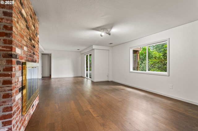 13980 Shireva Ct, Lake Oswego, OR 97034 - unfurnished living room with plenty of natural light, dark wood-style flooring, and a brick fireplace