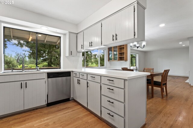 13980 Shireva Ct, Lake Oswego, OR 97034 - kitchen featuring dishwasher, a peninsula, light wood-type flooring, light countertops, and a chandelier