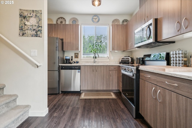 116 NE 109th Ave Unit A5, Portland, OR 97220 - kitchen with stainless steel appliances, dark wood-style flooring, a sink, baseboards, and light stone countertops