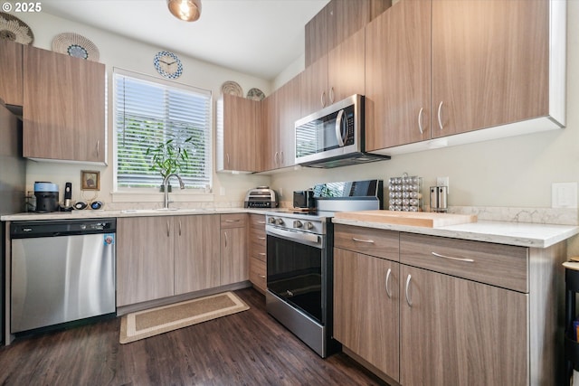116 NE 109th Ave, Portland, OR 97220 - kitchen with appliances with stainless steel finishes, a sink, dark wood-style floors, light brown cabinetry, and light stone countertops