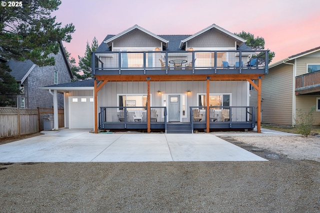 33515 Madrona Dr, Pacific City, OR 97135 - view of front facade featuring a balcony, board and batten siding, covered porch, concrete driveway, and an attached garage