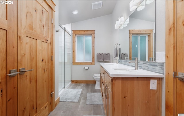 bathroom with lofted ceiling, tasteful backsplash, a shower stall, and vanity