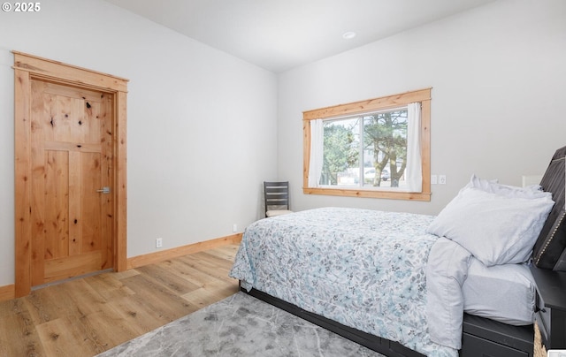 bedroom with baseboards and wood finished floors