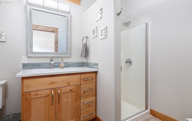 bathroom featuring toilet, a shower stall, and vanity