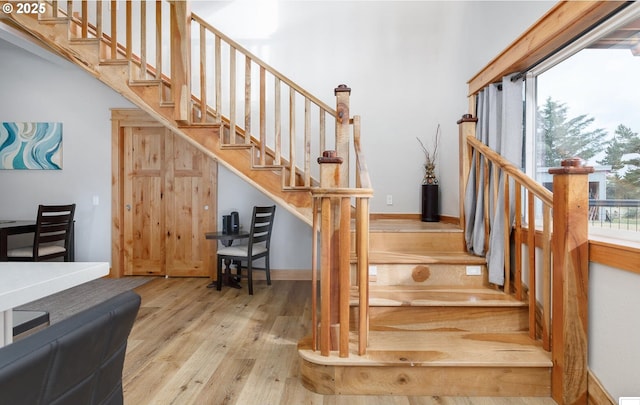 staircase featuring wood finished floors and baseboards