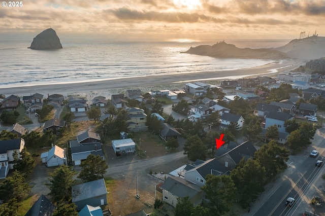 aerial view at dusk with a view of the beach, a residential view, and a water view