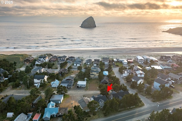 drone / aerial view featuring a residential view, a water view, and a beach view