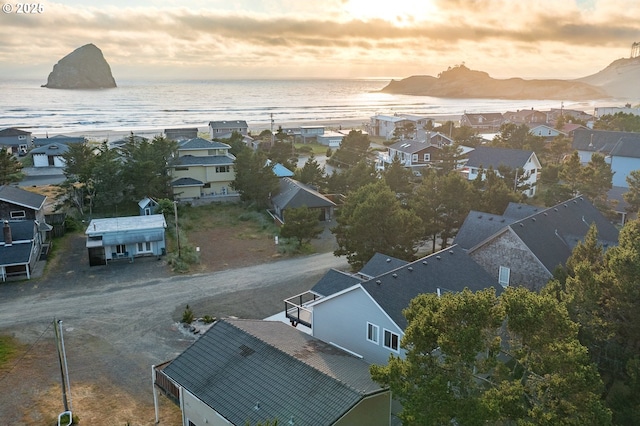 aerial view at dusk with a residential view and a water view