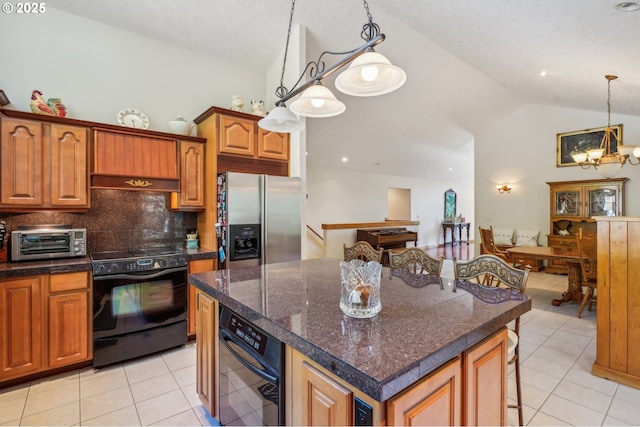 kitchen with black appliances, light tile patterned floors, a chandelier, a kitchen bar, and high vaulted ceiling