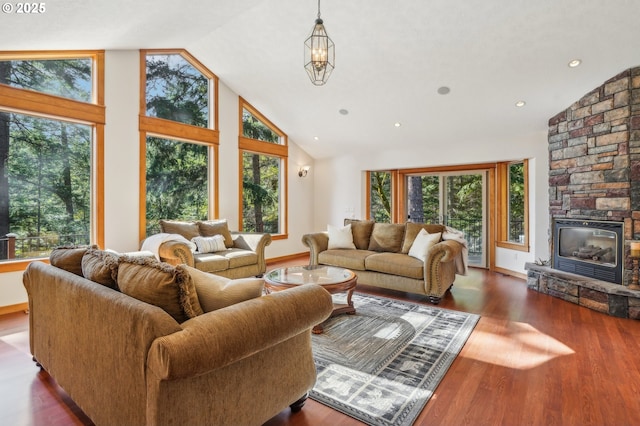 living room featuring high vaulted ceiling, wood finished floors, and baseboards