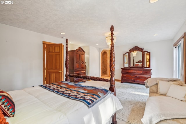 carpeted bedroom featuring a textured ceiling, arched walkways, and recessed lighting