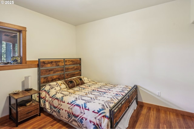 bedroom with baseboards and wood finished floors