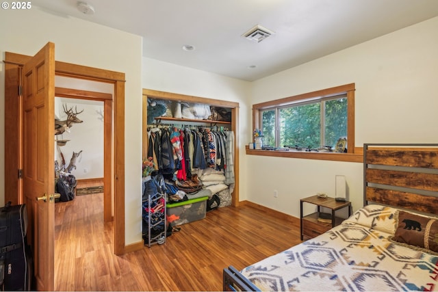 bedroom featuring wood finished floors, a closet, and baseboards