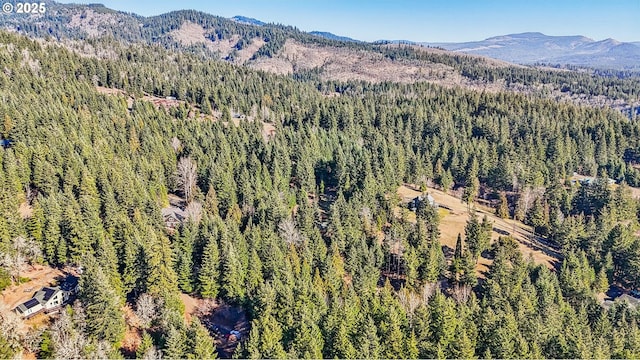 drone / aerial view featuring a forest view and a mountain view