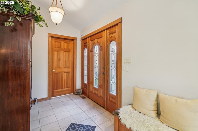 entryway with vaulted ceiling and light tile patterned floors