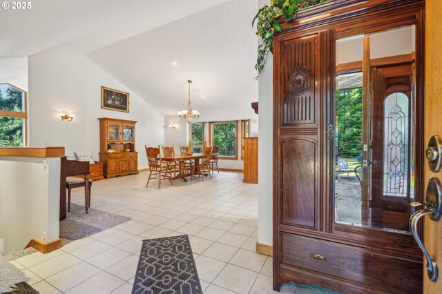 entrance foyer featuring light tile patterned floors, baseboards, a chandelier, and vaulted ceiling