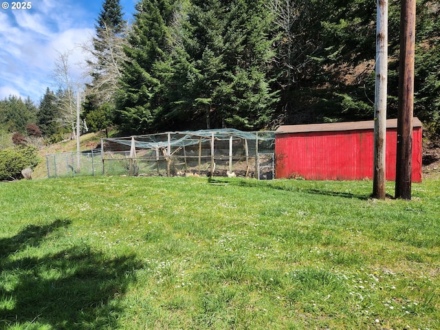 view of yard featuring fence and an outbuilding