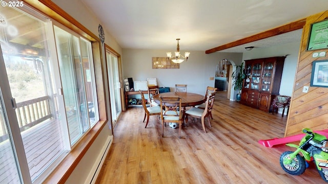 dining room with light wood-style flooring, a baseboard heating unit, a chandelier, and beamed ceiling