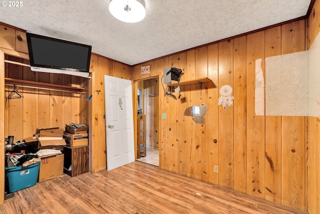 bedroom featuring wood finished floors and wood walls