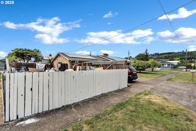 view of side of property with fence and solar panels