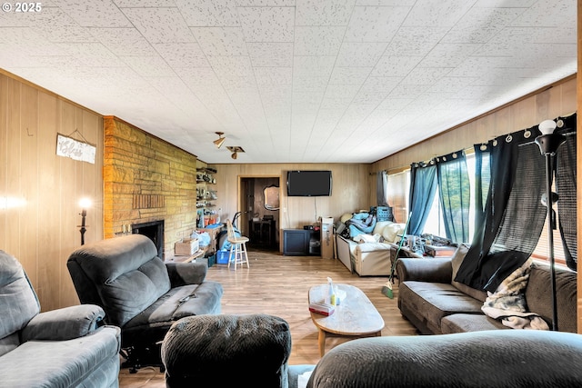 living area with wood walls, a fireplace, and wood finished floors