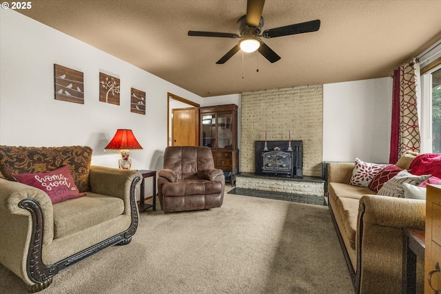 carpeted living area with a wood stove, ceiling fan, and a textured ceiling