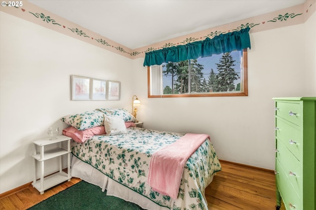 bedroom with wood finished floors and baseboards