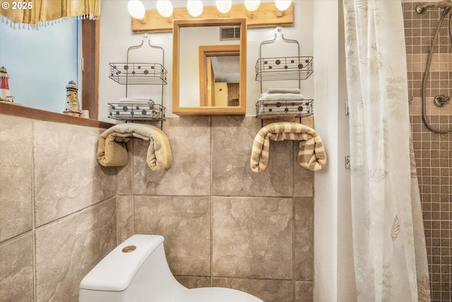 bathroom with toilet and a tile shower