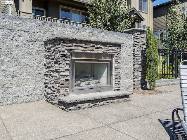 14215 SW Burlwood Ln, Beaverton, OR 97005 - exterior details with board and batten siding, fence, stone siding, and an outdoor stone fireplace