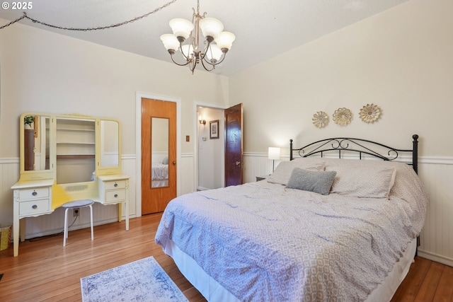 bedroom with a notable chandelier and wood-type flooring