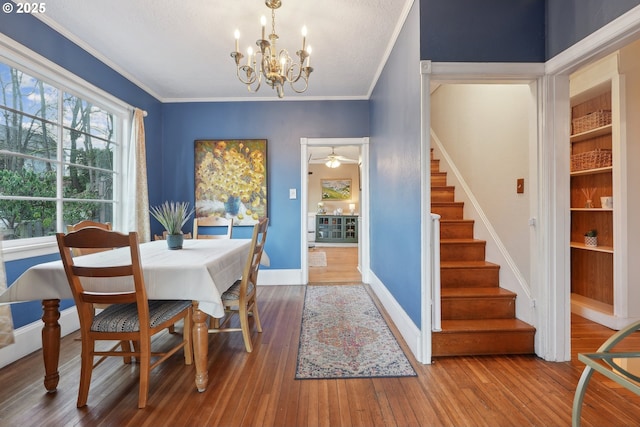 dining area featuring hardwood / wood-style flooring, ornamental molding, and a notable chandelier