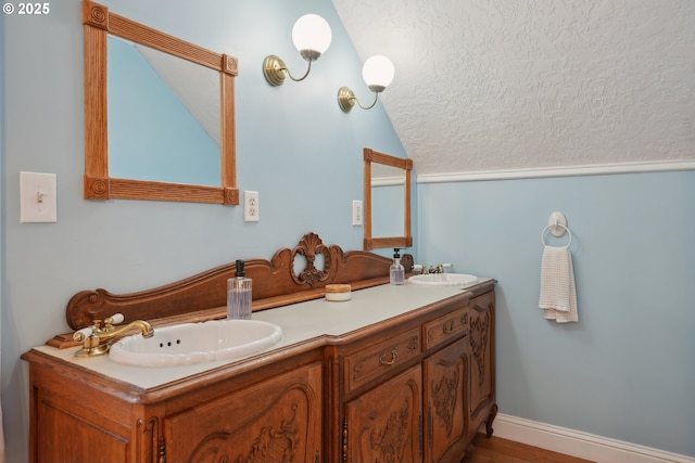 bathroom with vanity, lofted ceiling, and a textured ceiling