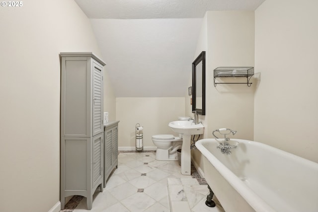 bathroom with a bathing tub, lofted ceiling, and toilet