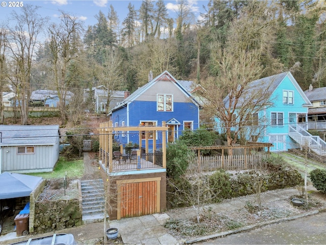 rear view of property featuring a shed and a wooden deck