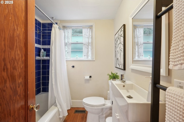 full bathroom with hardwood / wood-style flooring, a wealth of natural light, shower / bath combo with shower curtain, and toilet